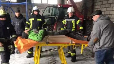 Рятувальники переносять травмованого до карети швидкої допомоги Рятувальники переносять травмованого до карети швидкої допомоги