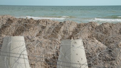 Узбережжя у Коблевому, яке огороджене фортифікаційними спорудами та колючим дротом Узбережжя у Коблевому, яке огороджене фортифікаційними спорудами та колючим дротом