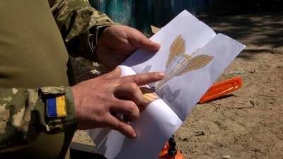 Житомирський військовий на підтримку побратимів вирізає з дерева герб 95 бригади Житомирський військовий на підтримку побратимів вирізає з дерева герб 95 бригади