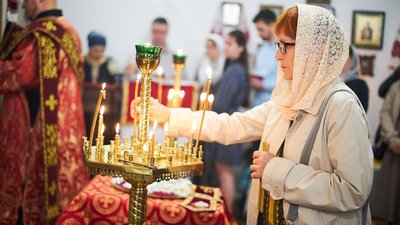 Церква. Жінка ставить свічку