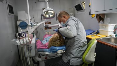 Андрій Романов оглядає пацієнтку в пересувному стоматологічному кабінеті