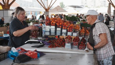 Чоловік купує полуницю на ринку у Харкові