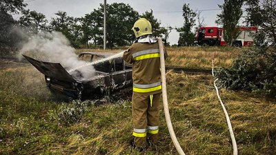 Надзвичайник гасить пожежу автомобіля Надзвичайник гасить пожежу автомобіля