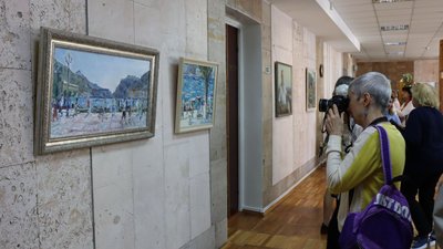 Відвідувачі виставки фотографують, розглядають картини Відвідувачі виставки фотографують, розглядають картини
