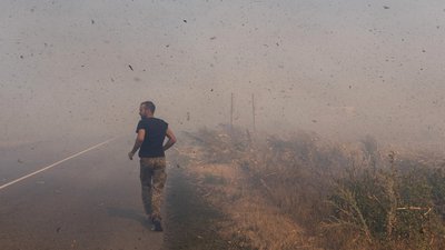 військовий біжить повз палаюче поле Донеччина