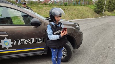 Діти роблять світлини біля поліцейської машини Діти роблять світлини біля поліцейської машини