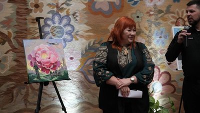 Людмила Мусіяка поруч з картиною сумських авторів.