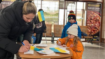 Вимушені переселенці з Донецької області підписують листівки для військових Вимушені переселенці з Донецької області підписують листівки для військових