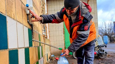 Чоловік набирає воду зі свердловини на Донеччині