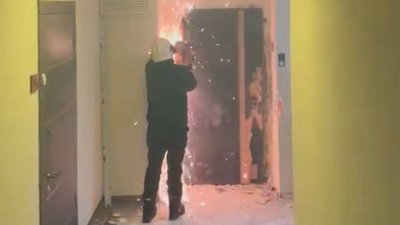 Правоохоронці випилюють двері, щоб потрапити у помешкання одного з підозрюваних 