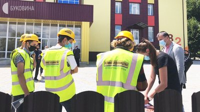 Працівники фірми-підрядника, яка будує школу у Рідківцях у брендованих жилетах та касках. Працівники фірми-підрядника, яка будує школу у Рідківцях у брендованих жилетах та касках.