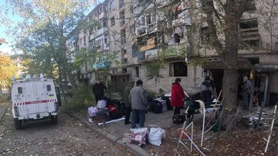 Люди біля під'їзду готуються до евакуації