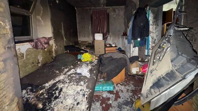 Кімната з обвугленими стінами, пошкодженими меблями та розкиданими речами