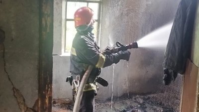 Рятувальник гасить пожежу у будинку в селі Селище