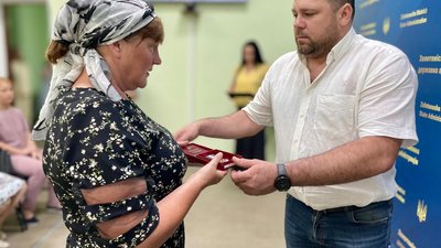 чоловік передає жінці нагороду