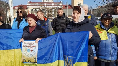 Учасники акції тримають в руках українські прапори та плакати Учасники акції тримають в руках українські прапори та плакати