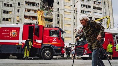Жінка йде біля будинку в Салтівському районі Харкова, в який влучила ракета