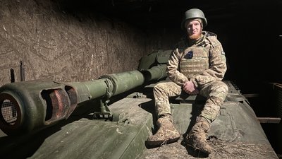Військовий сидить на САУ