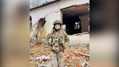 Бойова медикиня біля зруйнованого будинку Бойова медикиня біля зруйнованого будинку