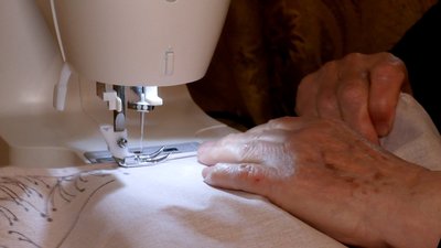 Волонтерка похилого віку шиє постільну білизну у Чернігові Волонтерка похилого віку шиє постільну білизну у Чернігові