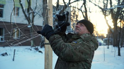 Військовий натягує антидронову стіку в Ізюмі