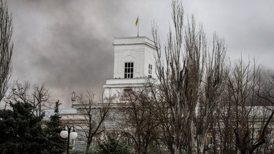 Обстріли Херсона, дим, темне небо, прапор