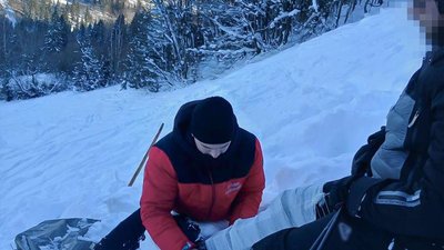 Рятувальник надає допомогу травмованому лижнику