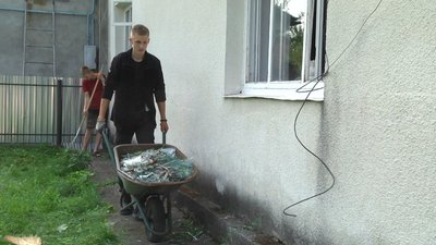 Старші сини Мар'яни прибирають уламки скла з подвір'я будинку. Старші сини Мар'яни прибирають уламки скла з подвір'я будинку.