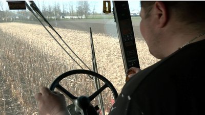 Фермер збирає кукурудзу, яку на зиму лишив у полі Фермер збирає кукурудзу, яку на зиму лишив у полі