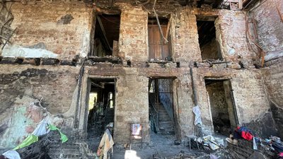 Попіл під ногами. Мешканці пошкодженого обстрілами будинку розчищають оселі Попіл під ногами. Мешканці пошкодженого обстрілами будинку розчищають оселі