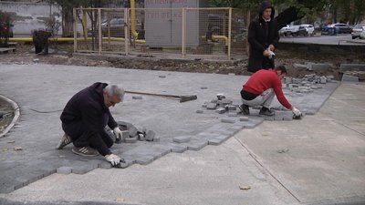 Робітники вкладають плитку Робітники вкладають плитку