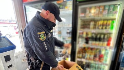 Поліцейський перевіряє коробку з алкоголем