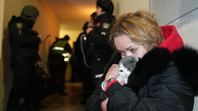 Жінка обіймає свою кішку в укритті