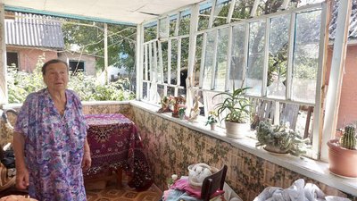 Парасковія Довга на веранді власного будинку. Там вибито скло та зірвано покриття. Меджибізька громада, 21 серпня 2023. Парасковія Довга на веранді власного будинку. Там вибито скло та зірвано покриття. Меджибізька громада, 21 серпня 2023.