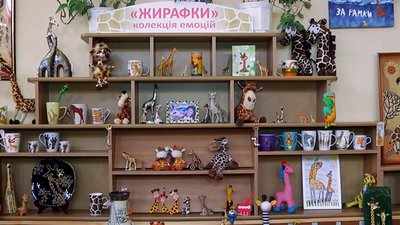 Статуетки, іграшки, картини, сумки, футболки, вази, наліпки, книги, блокноти, чашки, значки і це ще не всі жирафи – експонати, які представлені глядачам Статуетки, іграшки, картини, сумки, футболки, вази, наліпки, книги, блокноти, чашки, значки і це ще не всі жирафи – експонати, які представлені глядачам