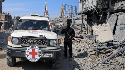 Бойовик ХАМАСу стоїть біля автівки Червоного Хреста