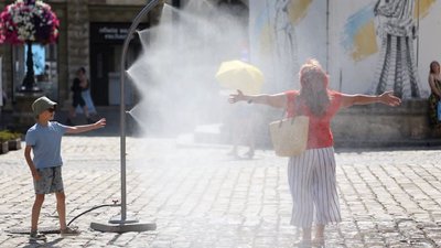 Жінка охолоджується під розпилювачем для води у Львові