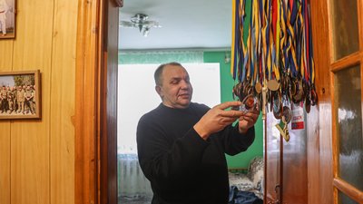 Батько показує медалі полеглого на війні сина Батько показує медалі полеглого на війні сина