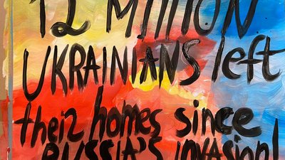 Дівчина з Нової Каховки малює плакати на для мітингів на підтримку України у Лісабоні