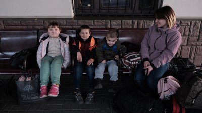 Жінка з дітьми на залізничному вокзалі Жінка з дітьми на залізничному вокзалі