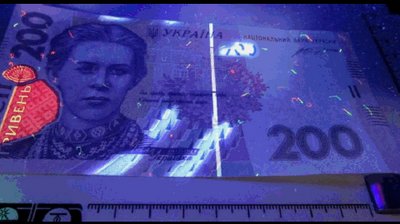 Підроблена банкнота в ультрафіолетових променях