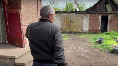 Чоловік на подвір'ї після обстрілу
