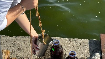 Інспекторка здійснює забір води для дослідження Інспекторка здійснює забір води для дослідження