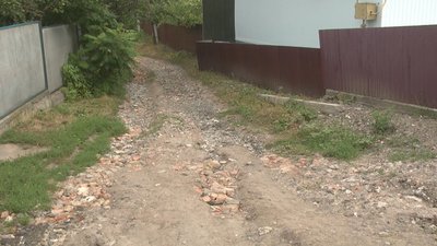 Через занадто крутий з'їзд та вибиті дощем канави на вулицю не може заїхати жодна машина. Фото: Суспільне. Через занадто крутий з'їзд та вибиті дощем канави на вулицю не може заїхати жодна машина. Фото: Суспільне.