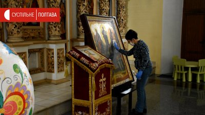 Працівниця собору дезінфікує поверхні Працівниця собору дезінфікує поверхні