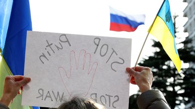 Плакат на антивоєнній акції з закликом зупинити війну