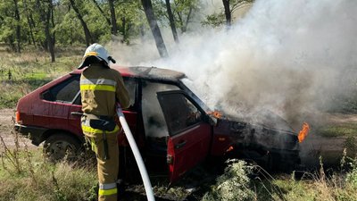 Рятувальник гасить пожежу авто