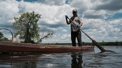Житель Печенігів Олександр Прошутя пливе на човні 