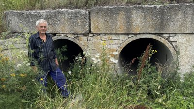Володимир біля бетонних труб, в яких родина ховалася від російських дронів