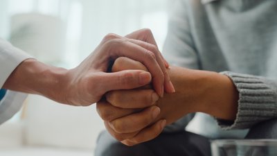 психологиня тримає за руку жінку
